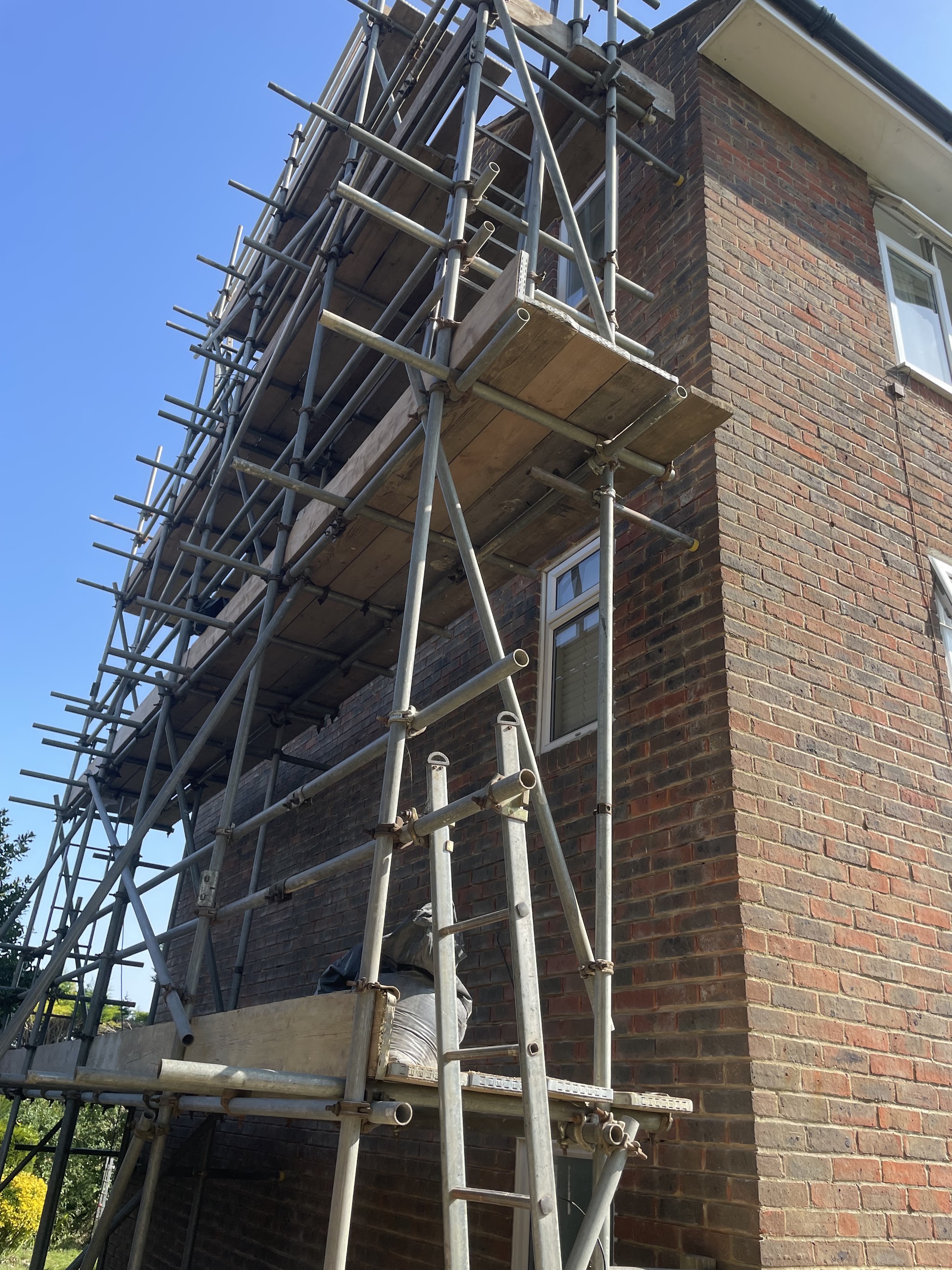 Scaffold tower against a tall brick gable